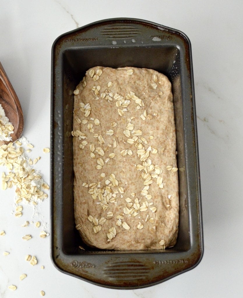 Overview look of 1 loaf of bread with wooden spoon in background. 