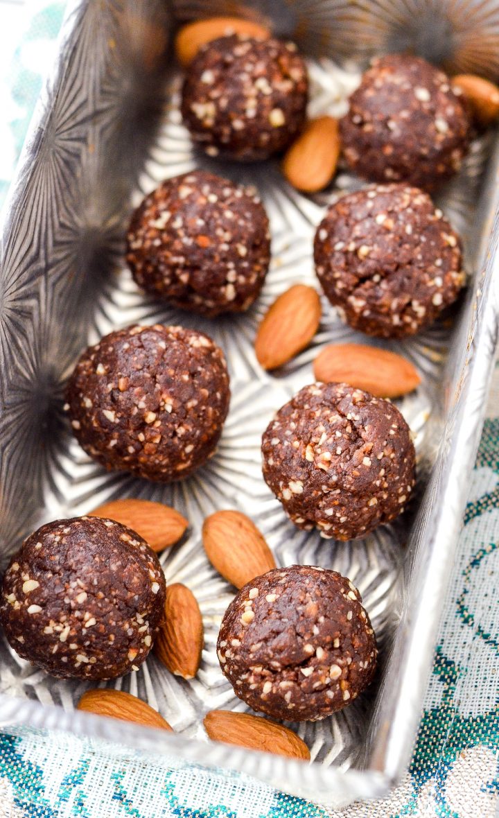 overhead view of 8 almond butter protein balls in a silver pan
