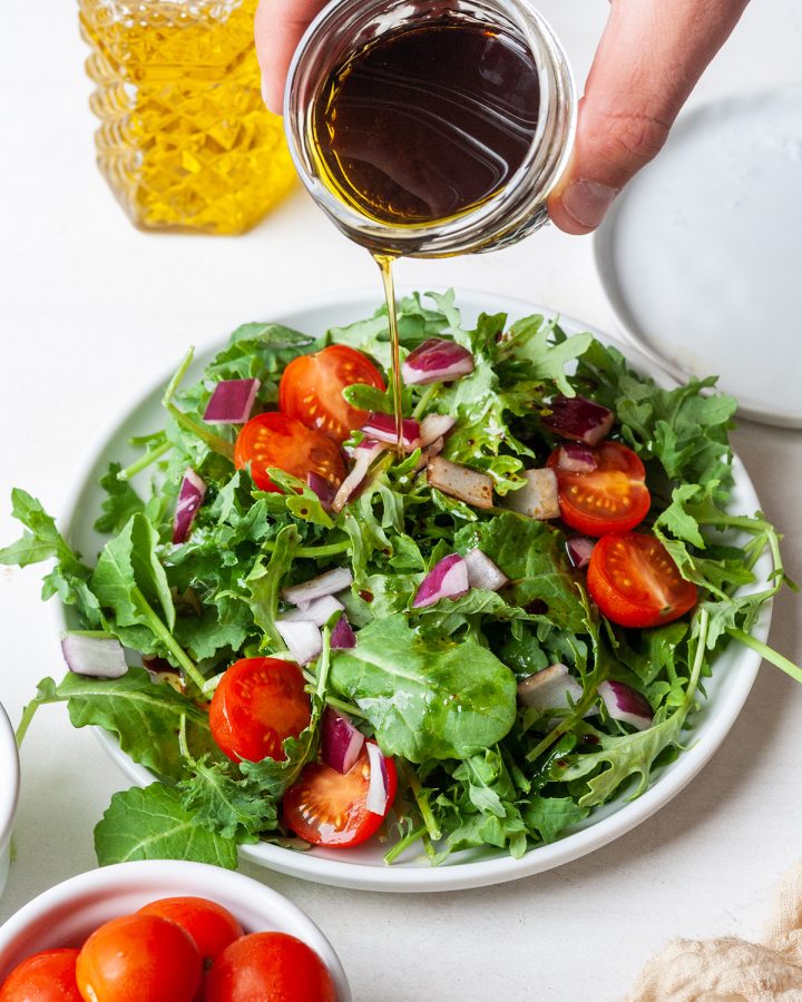 Maple Balsamic Vinaigrette Dressing being poured over a salad