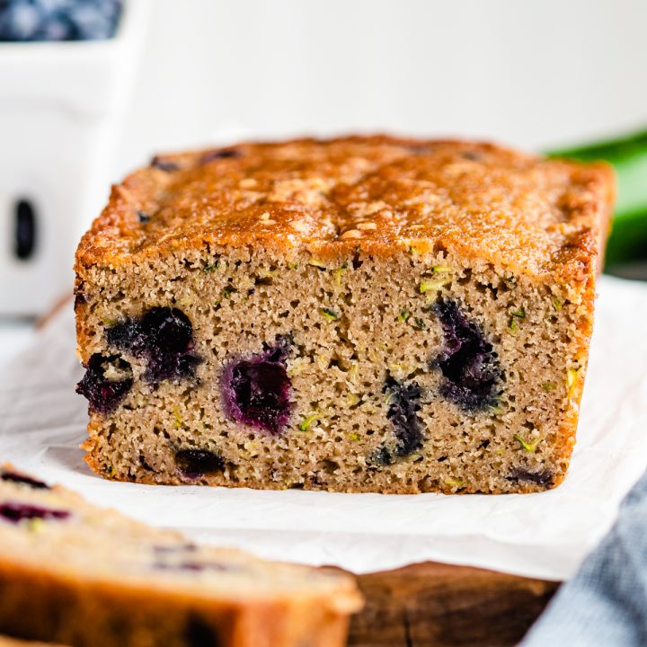 a loaf of Blueberry Zucchini Bread with two slices cut out of it