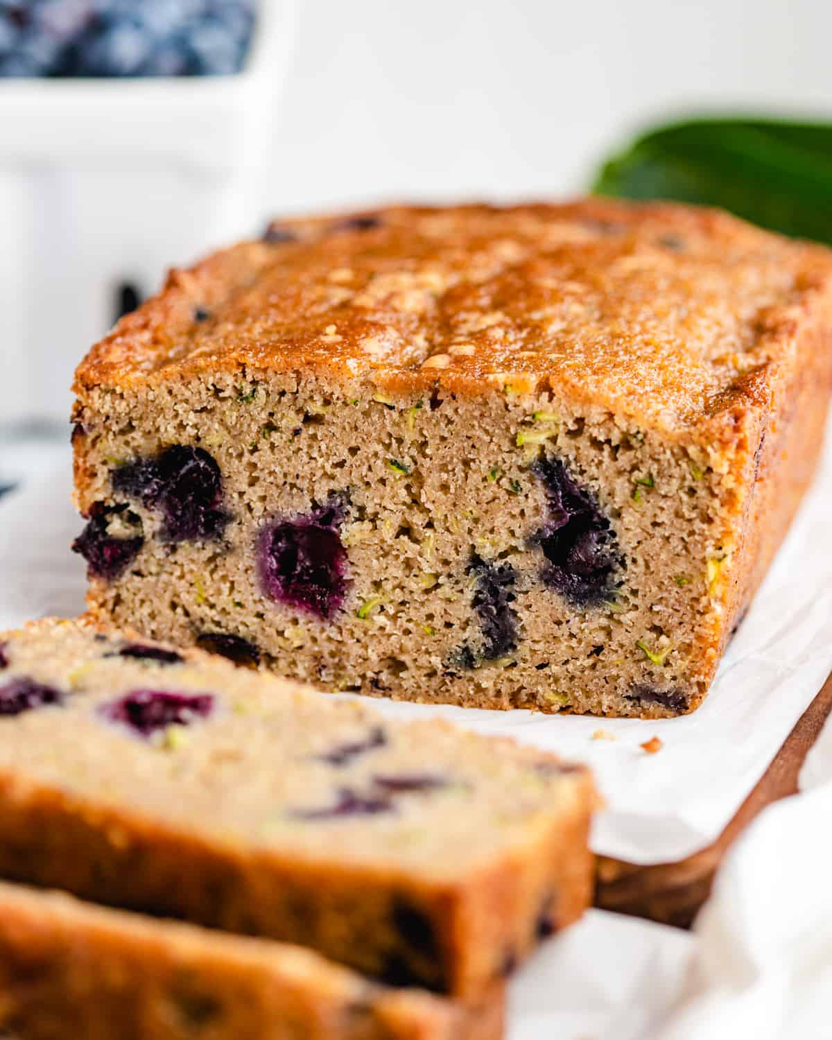 a loaf of Blueberry Zucchini Bread with two slices cut out of it