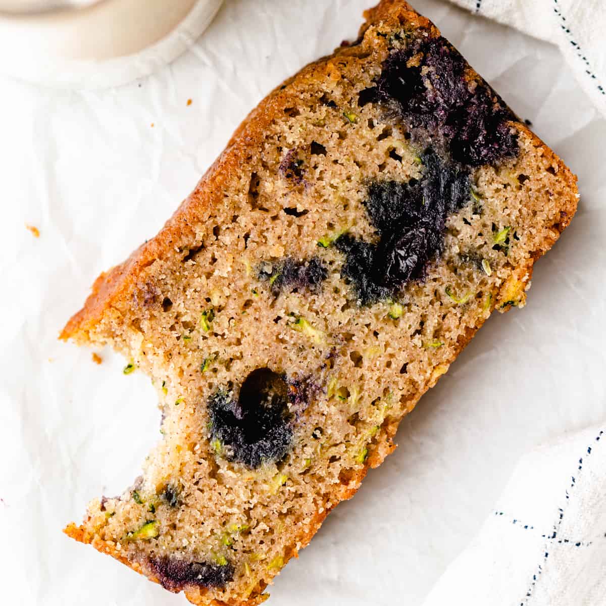 a slice of Blueberry Zucchini Bread with a bite taken out of it 