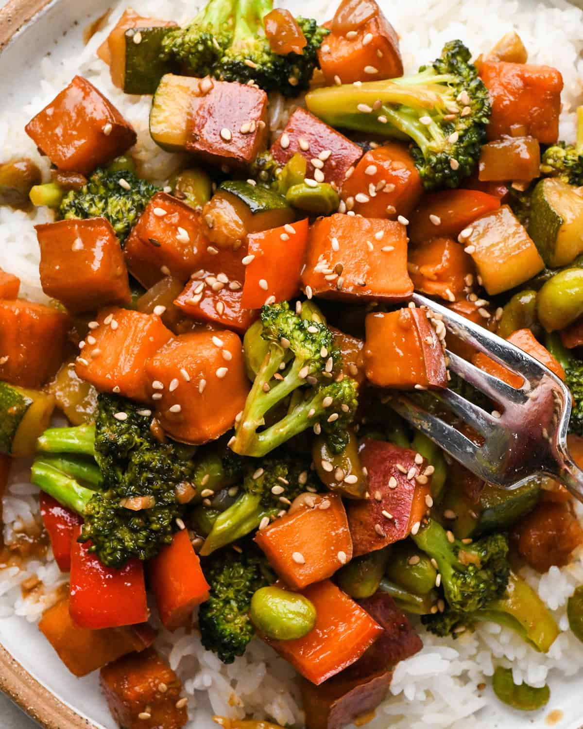 a fork taking a bite of Sweet Potato Stir Fry