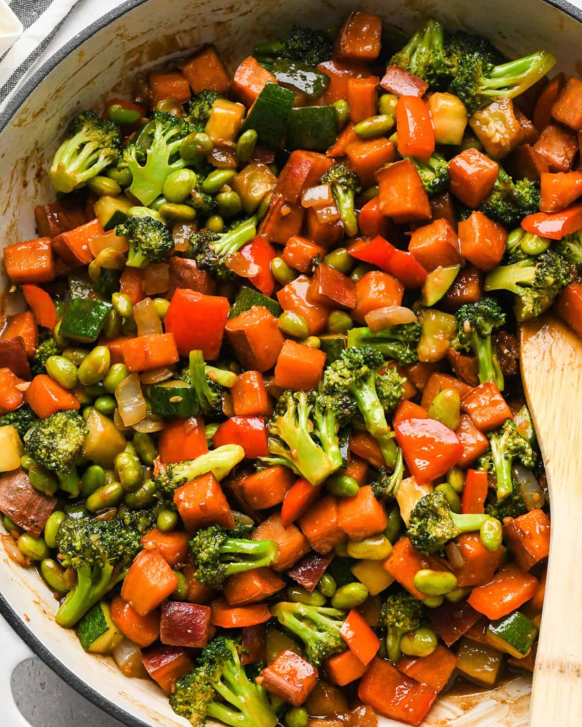 Sweet Potato Stir Fry in a pan with a wooden spatula 