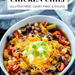 Overview image of crockpot chicken chili in bowl with toppings.