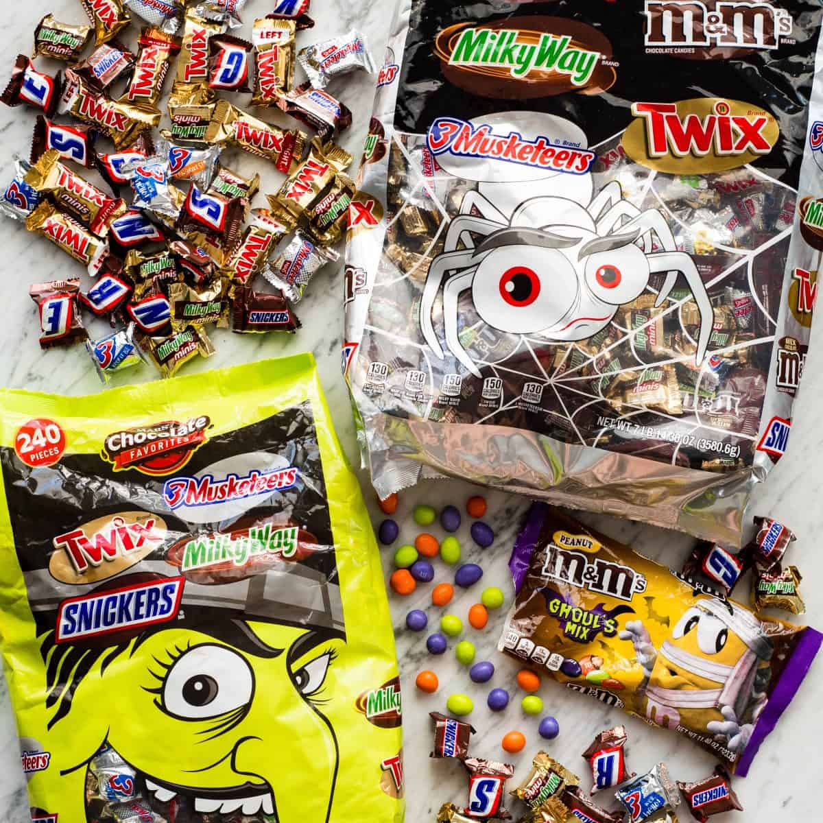 overhead photo of all sorts of chocolate candy to use in these candy cookie bars like snickers, twix, milky way and M&Ms