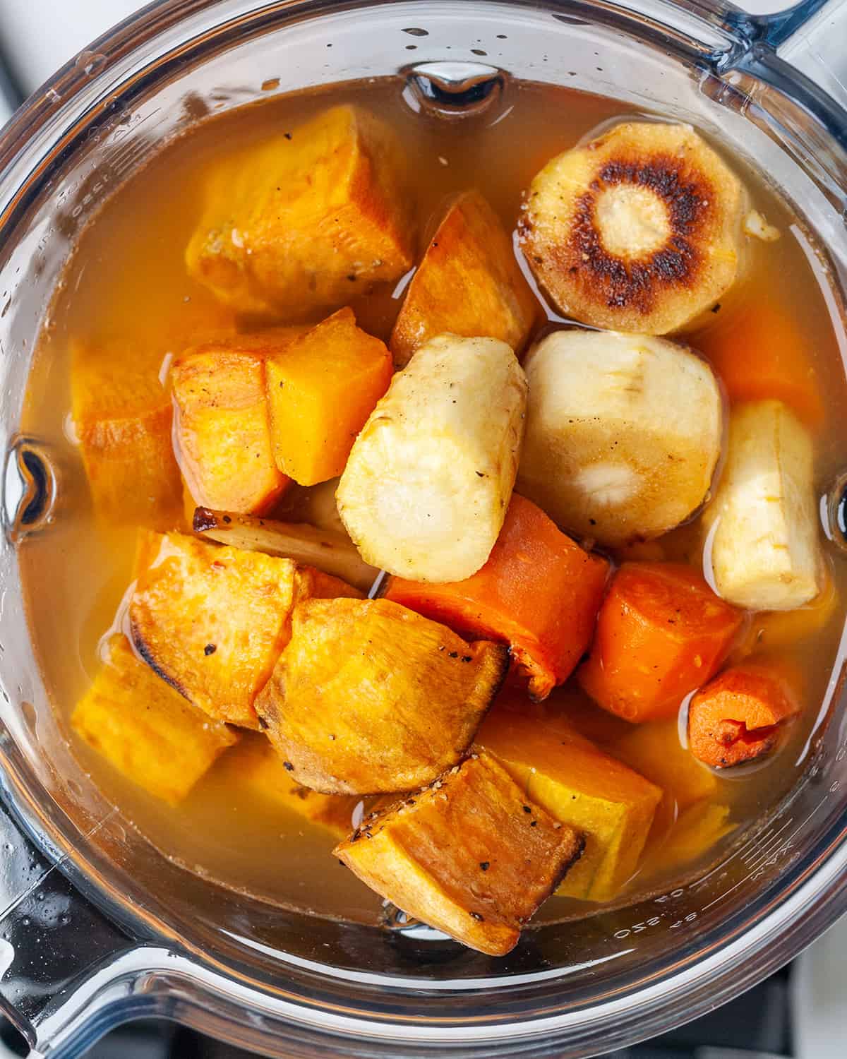 roasted vegetables and broth in the contianer of a vitamix to make Roasted Vegetable Soup