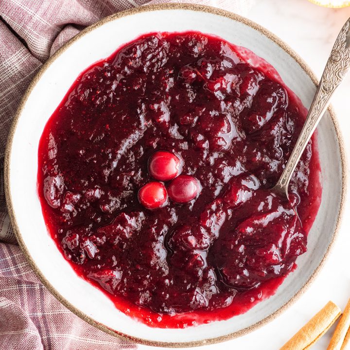 overhead view of a bowl of homemade cranberry sauce with a spoon in it