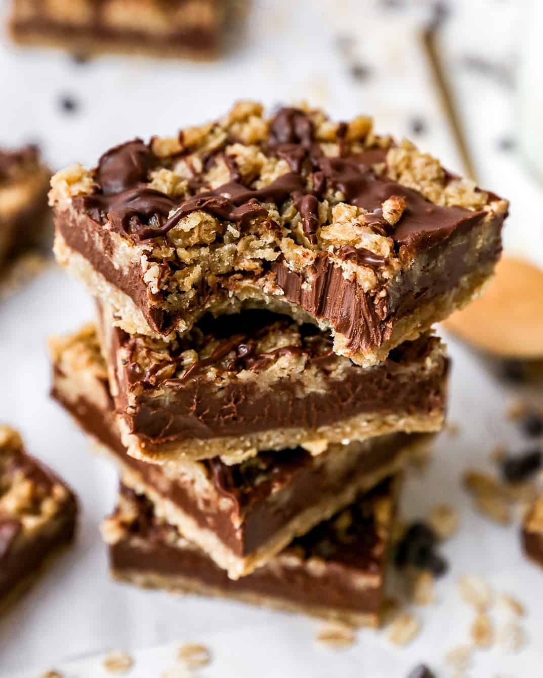 a stack fo 4 No-Bake Chocolate Peanut Butter Oatmeal Bars, the top one has a bite taken out of it