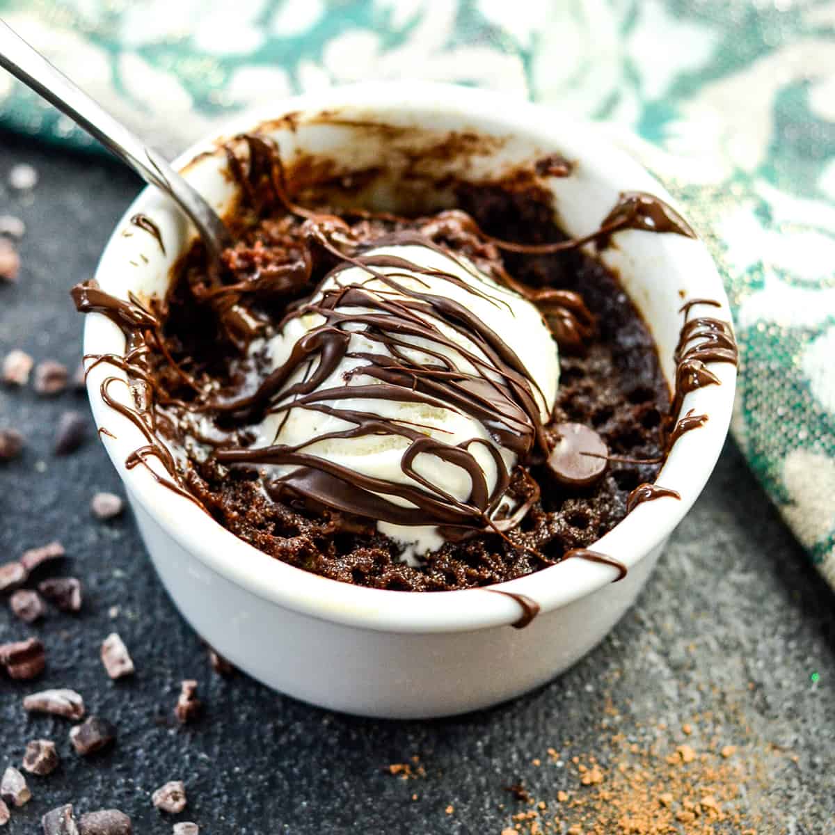 front view of a healthy mug Brownie with paleo vanilla ice cream and a chocolate drizzle. 
