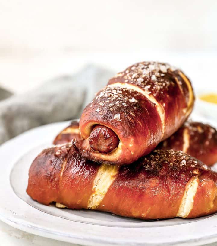 front view of three pretzel dogs on a plate