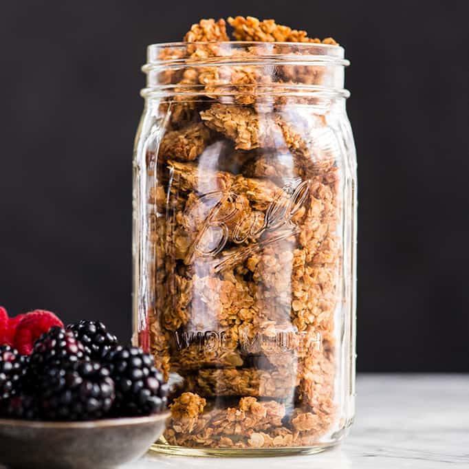 front view of a glass jar filled with peanut butter granola 
