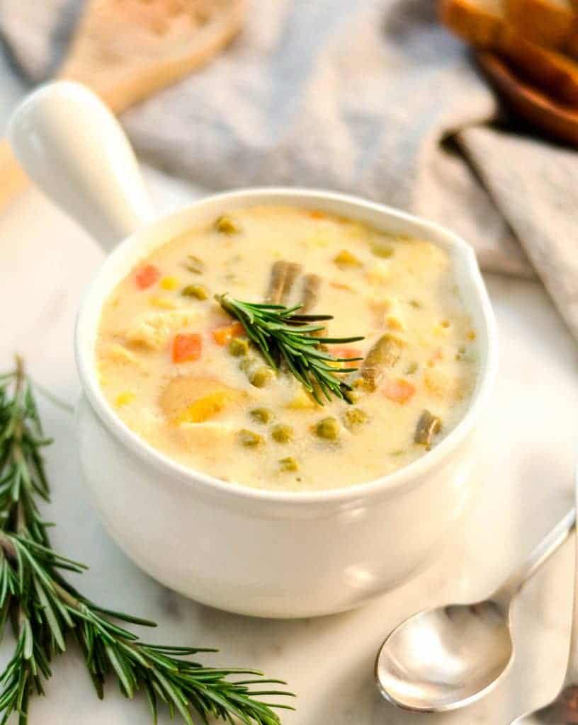 overhead view of Slow Cooker Chicken Pot Pie Soup in a white soup bowl with a handle
