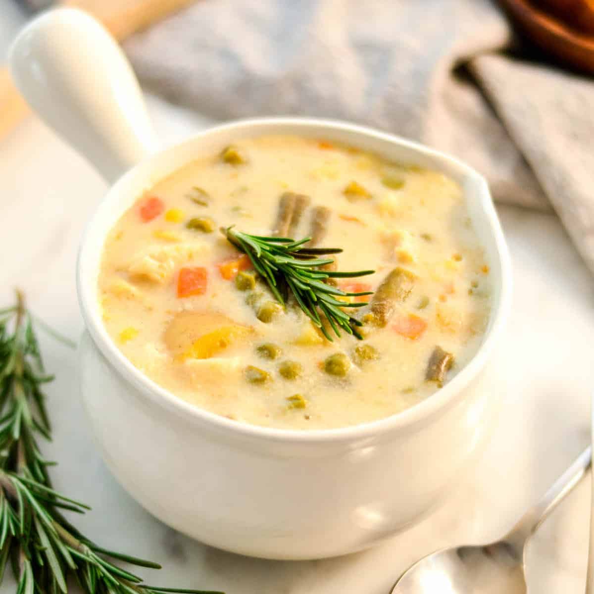 overhead view of Slow Cooker Chicken Pot Pie Soup in a white soup bowl with a handle