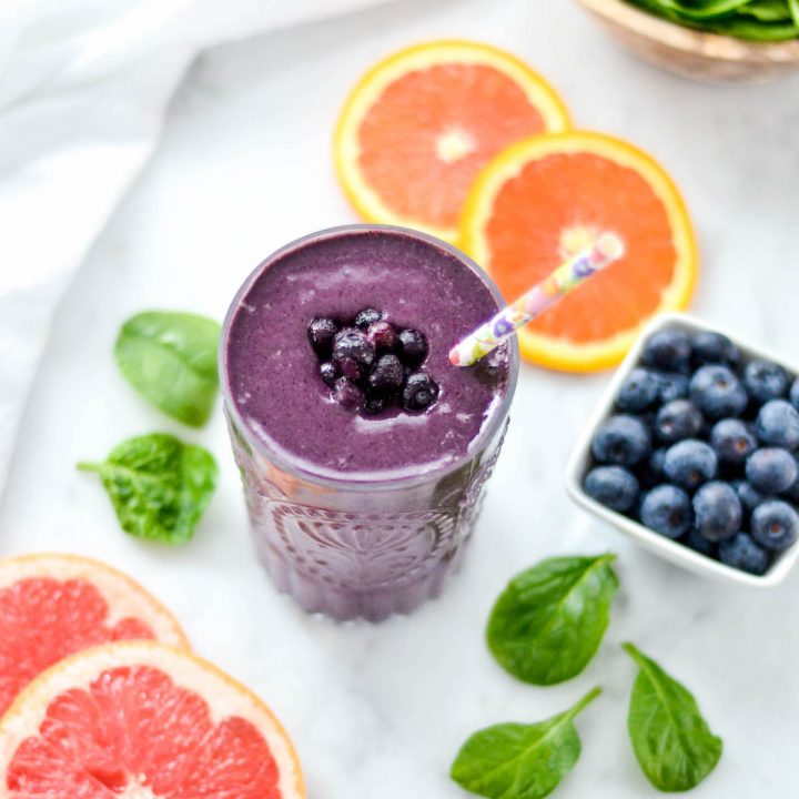 Overhead side view of a glass of Blueberry Citrus Smoothie with Spinach