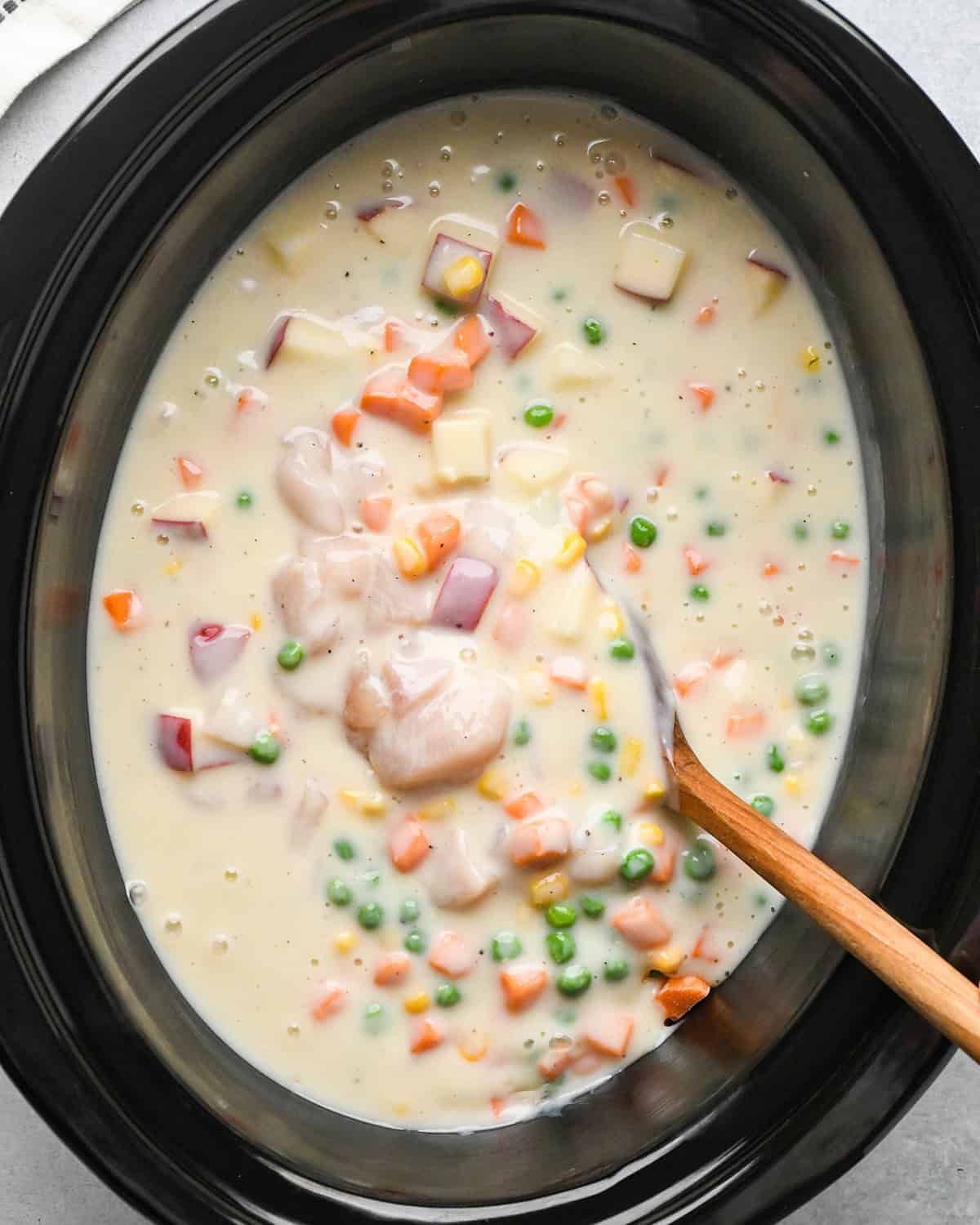 making Chicken Pot Pie Soup - soup added and stirred into the ingredients in the slow cooker