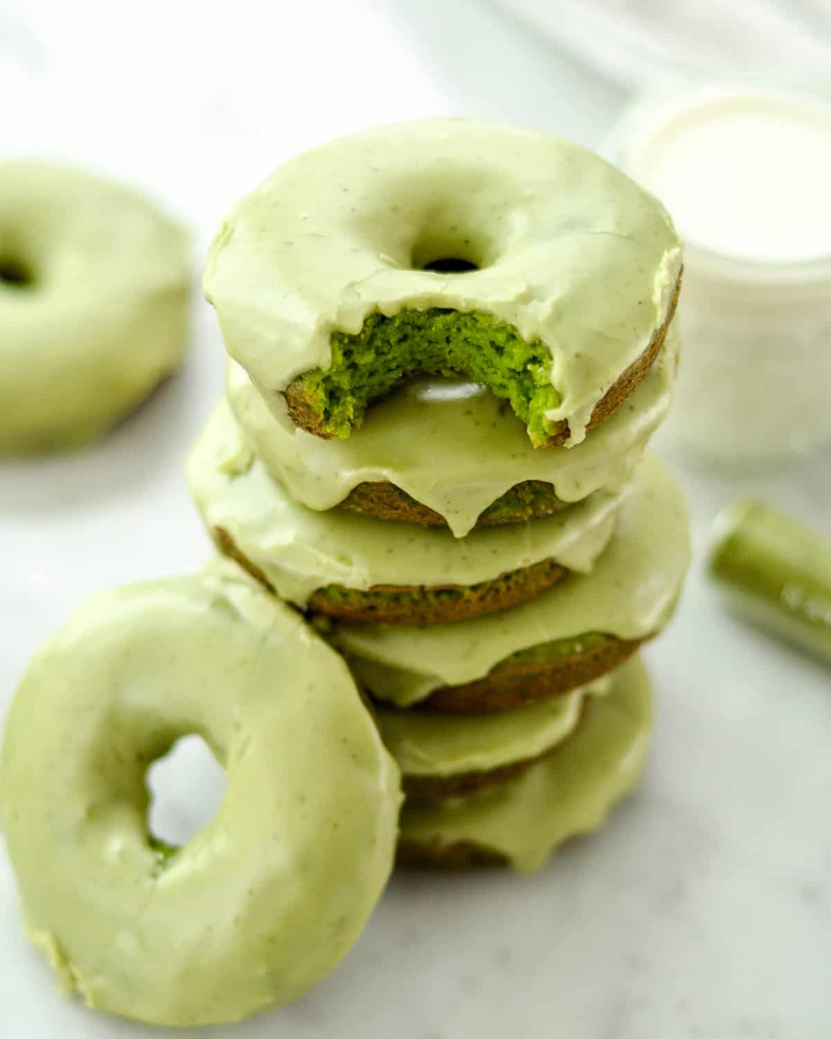 front view of a stack of 6 Paleo Spinach Donuts the top one has a bite taken out of it