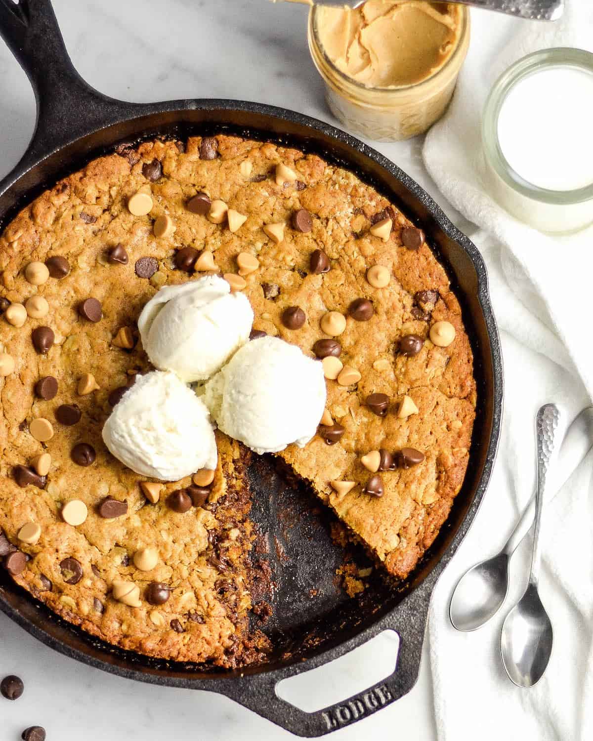 Overhead view of Healthy Skillet Peanut Butter Cookie with ice cream on top and one triangular piece cut out