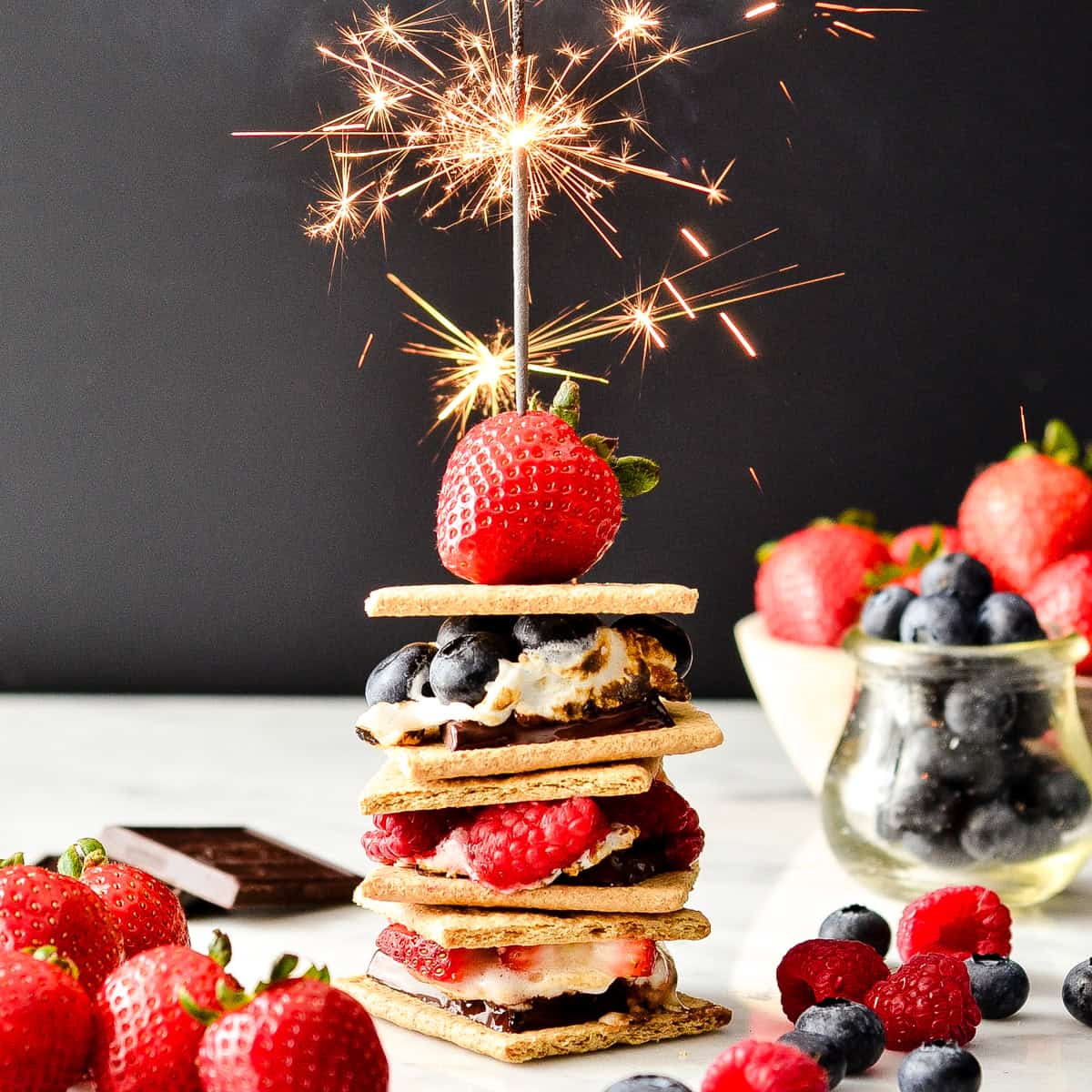 a stack of 3 Berry S'mores with a sparkler on top
