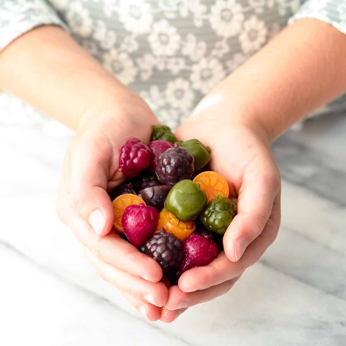 Kid's hands holding a handful of Homemade Fruit Snacks recipe