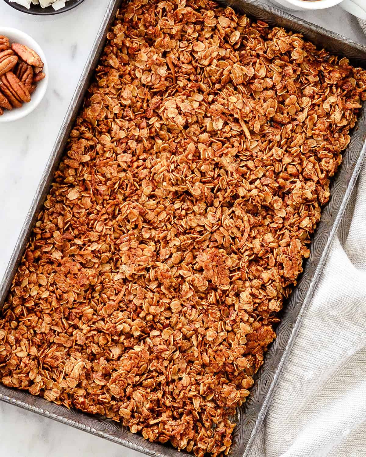 How to Make Homemade Granola - baked granola in a baking sheet
