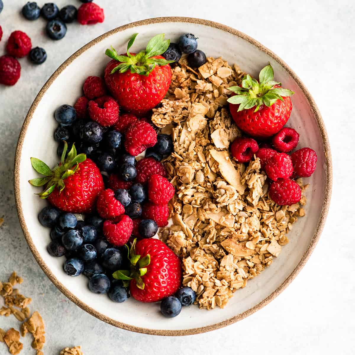 overhead view of a bowl of healthy homemade granola with berries