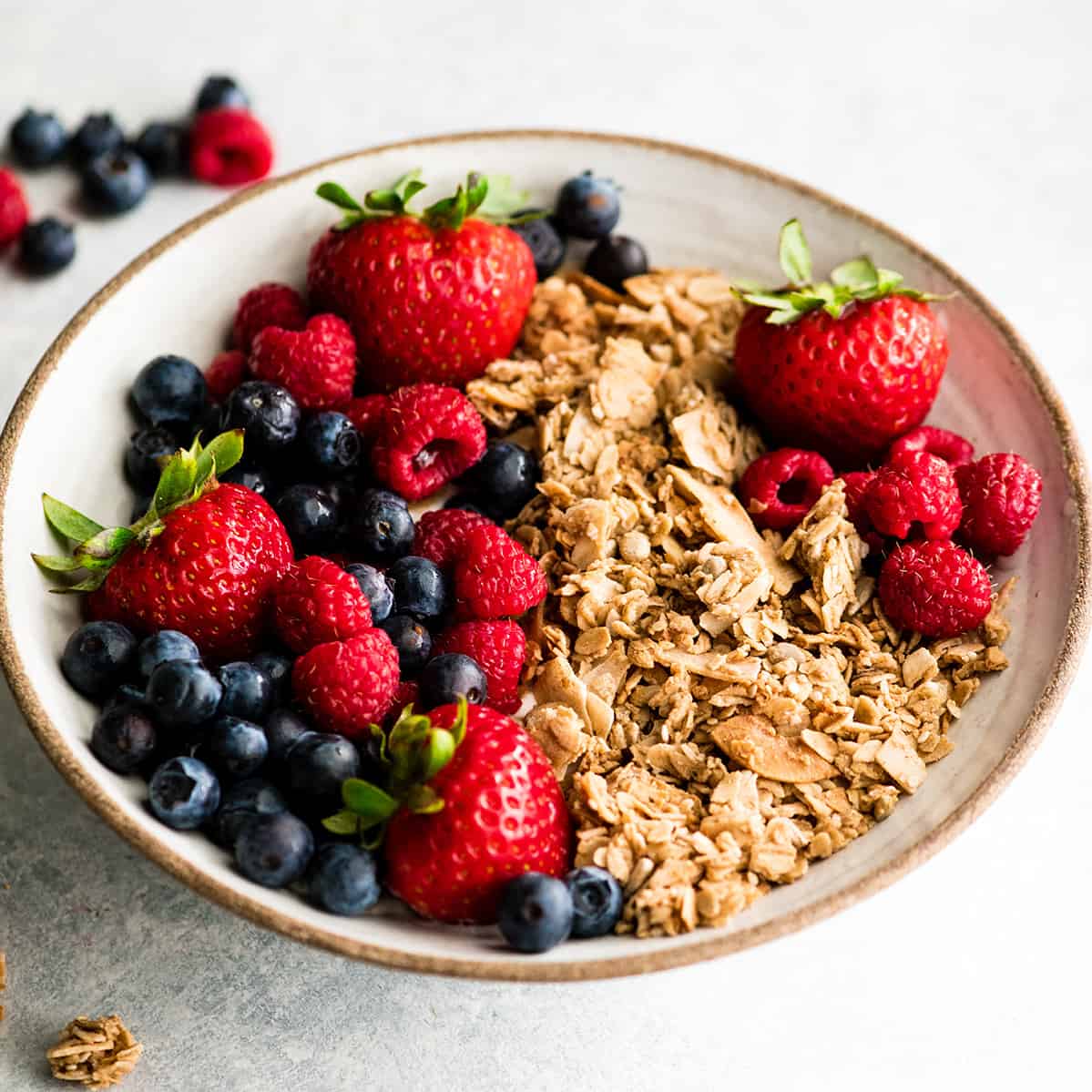 front view of a bowl of homemade granola recipe with berries