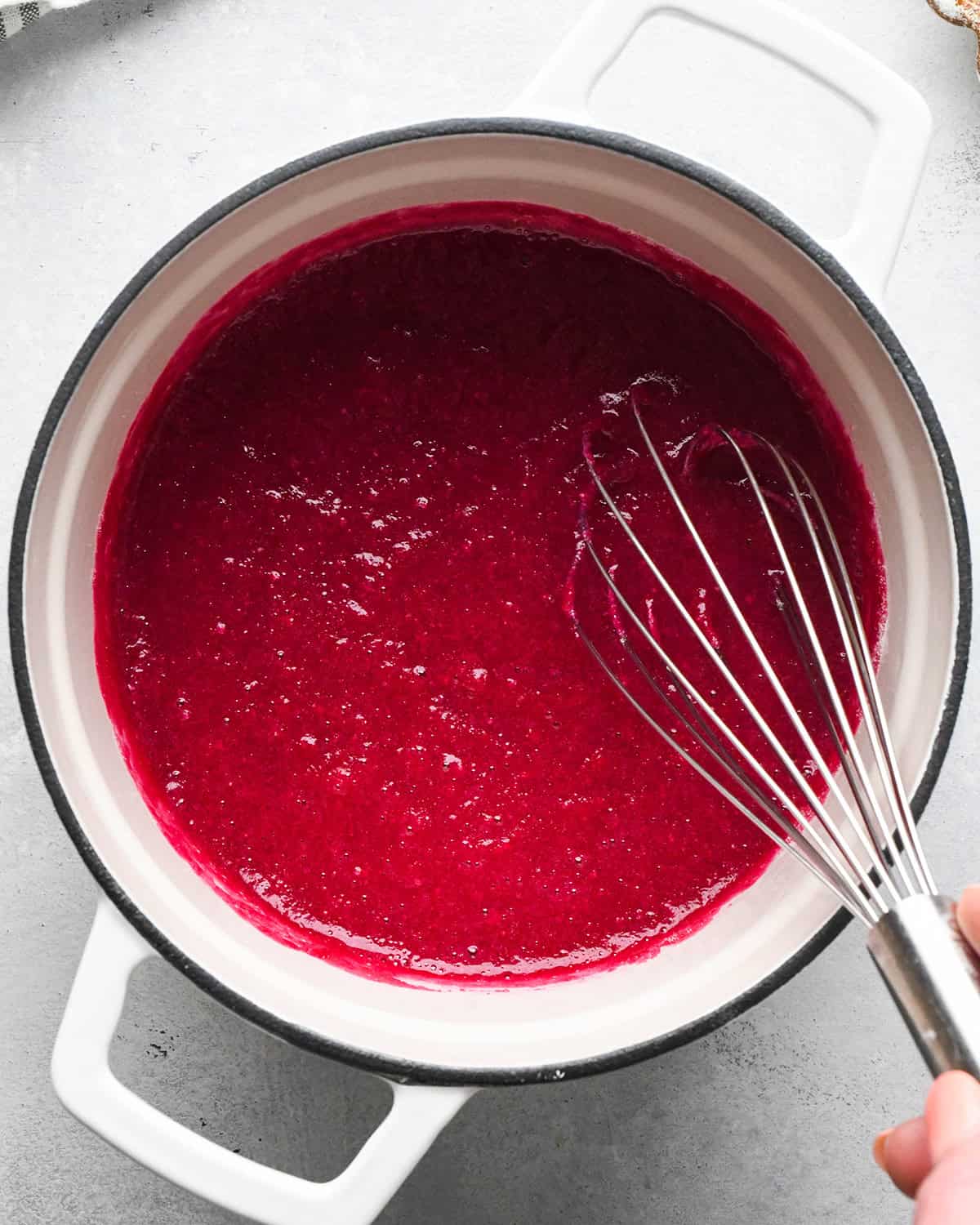 whisking gelatin into fruit snacks mixture in a sauepan