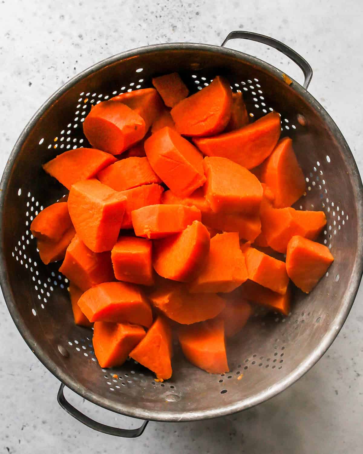 How to Make Sweet Potato Baby Food - sweet potatoes draining in a colander