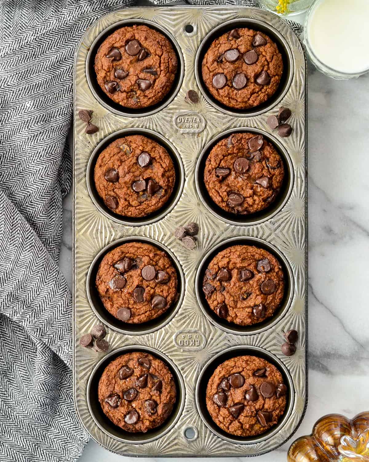 Overhead view of a muffin tin with eight Paleo Pumpkin Muffins 