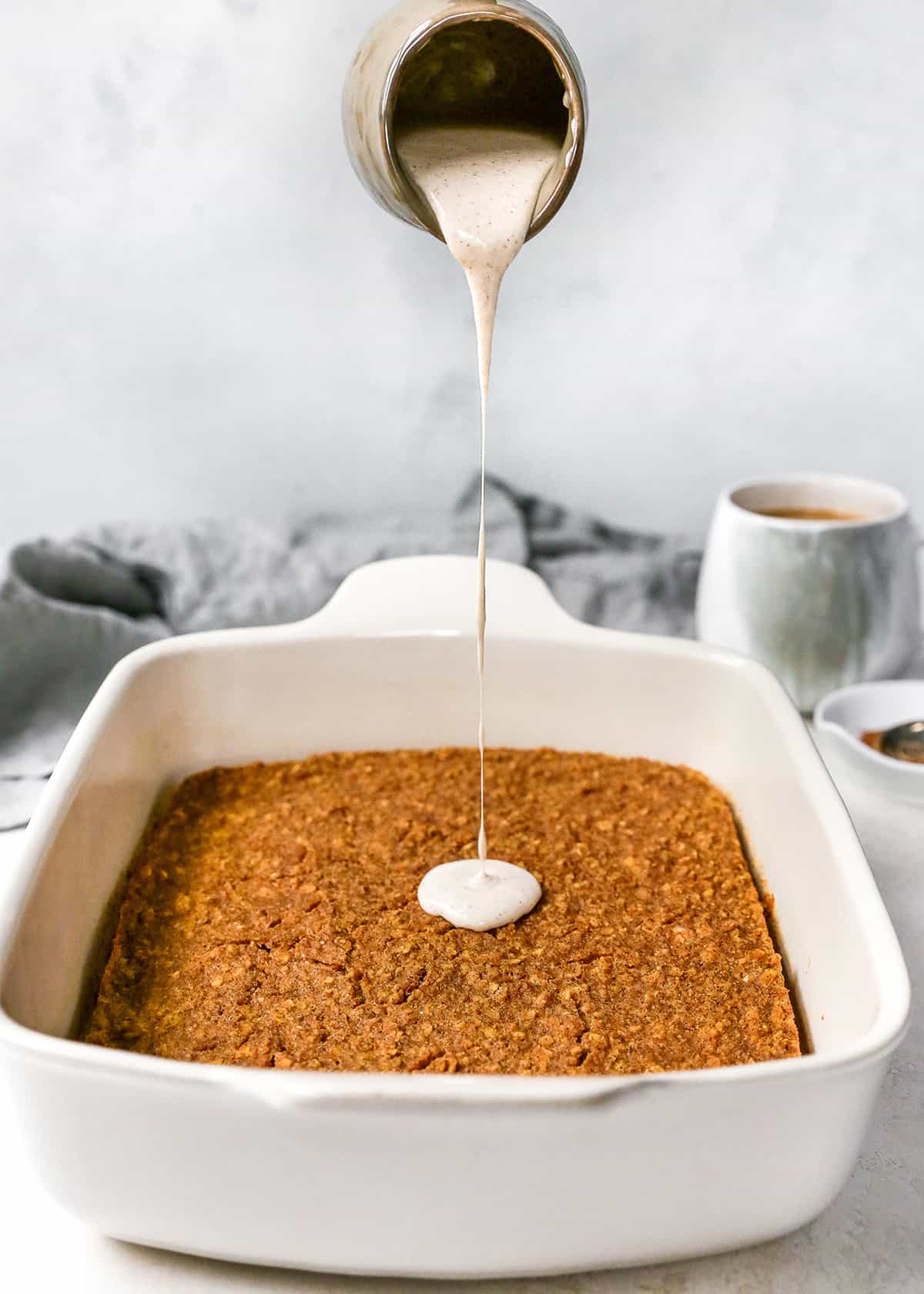 glaze being poured on top of baked pumpkin oatmeal