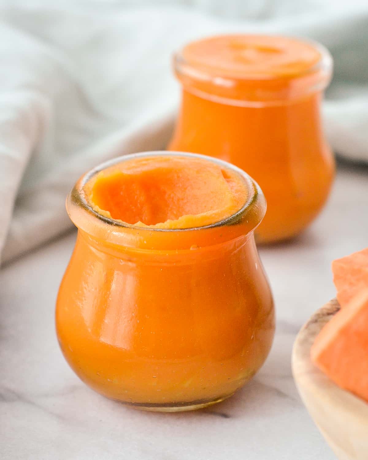 Front view of a jar of Sweet Potato Baby Food with a scoop taken out