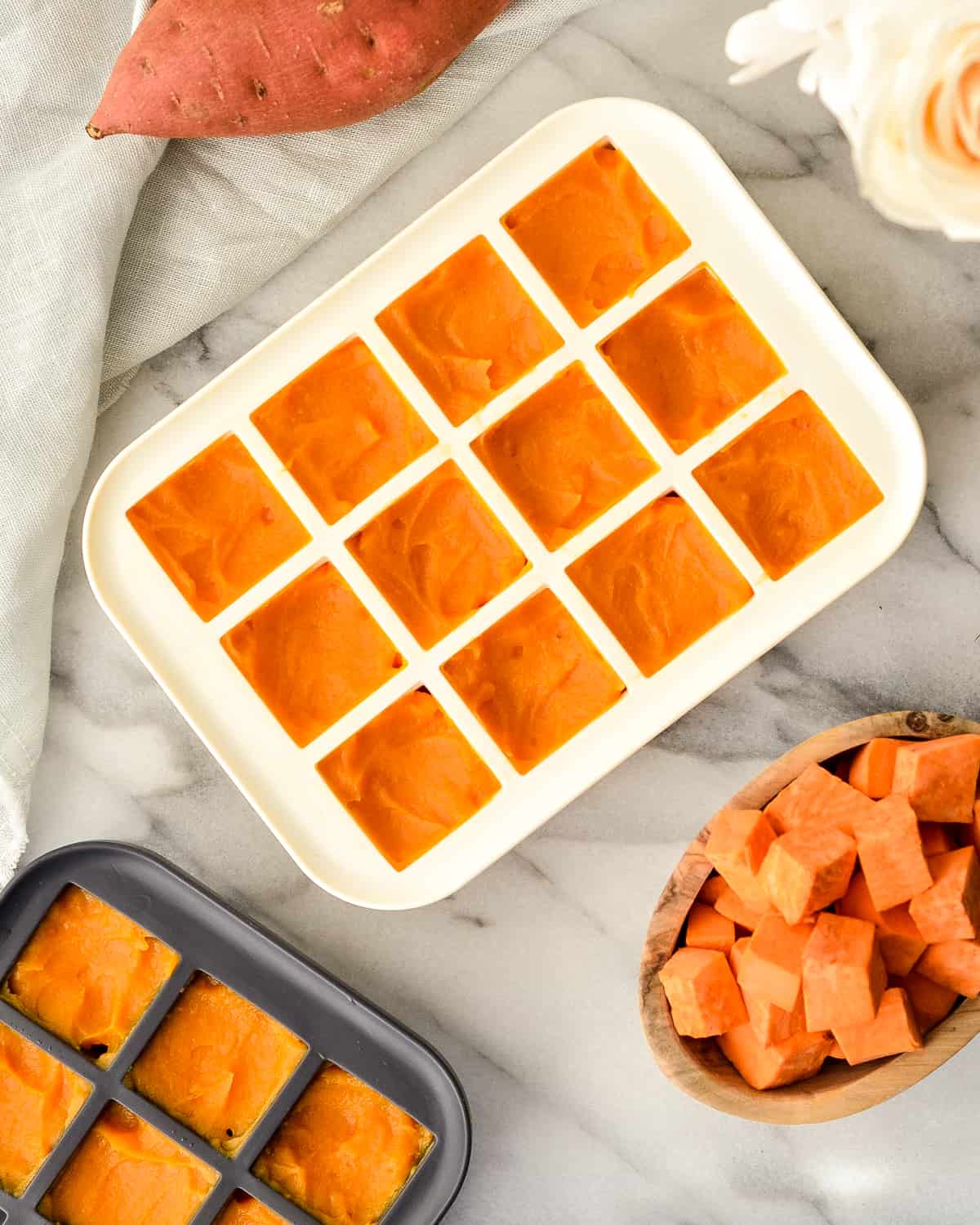 Overhead view of Sweet Potato Baby Food in silicone ice cube trays ready to be frozen