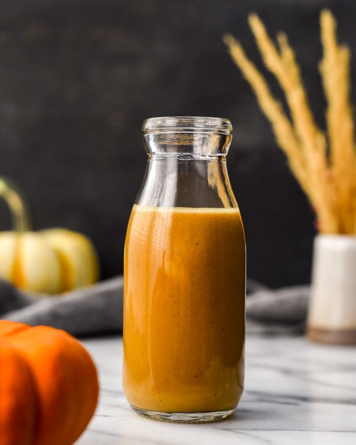 Front view of a glass bottle filled with Homemade Pumpkin Coffee Creamer 