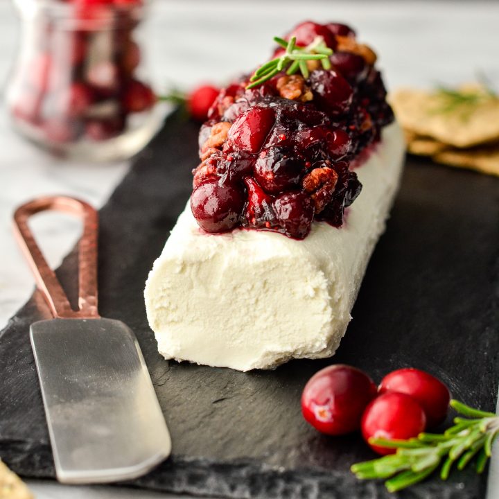 a goat cheese log made into a Cranberry Goat Cheese Appetizer on a serving platter
