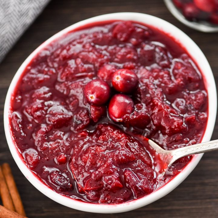 overhead view of a bowl of Healthy Cranberry Sauce with a spoon in it