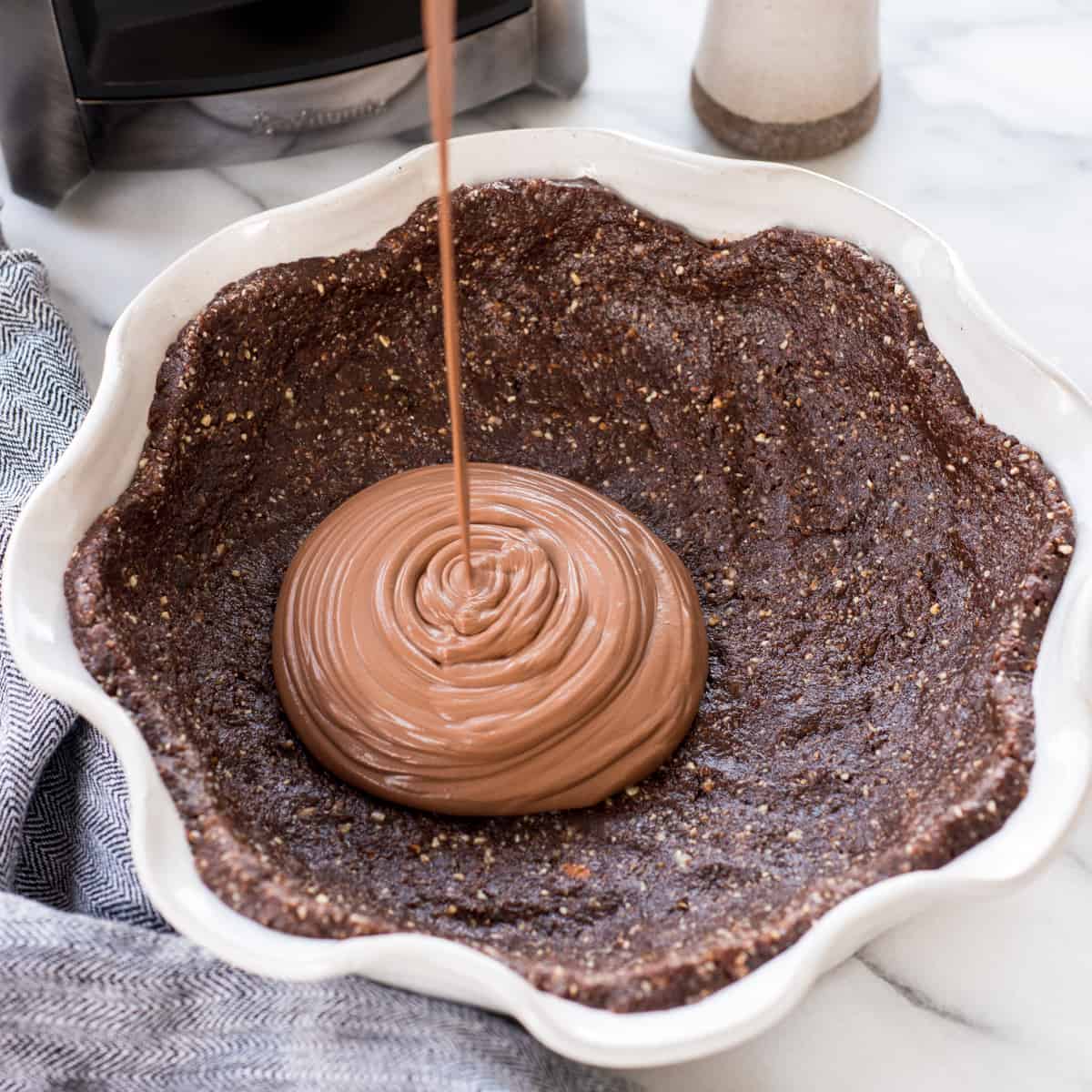 Vegan Chocolate Pie filling being poured into the crust