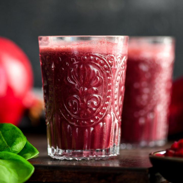 front view of two glasses filled with Beet & Pomegranate Smoothie with Spinach 