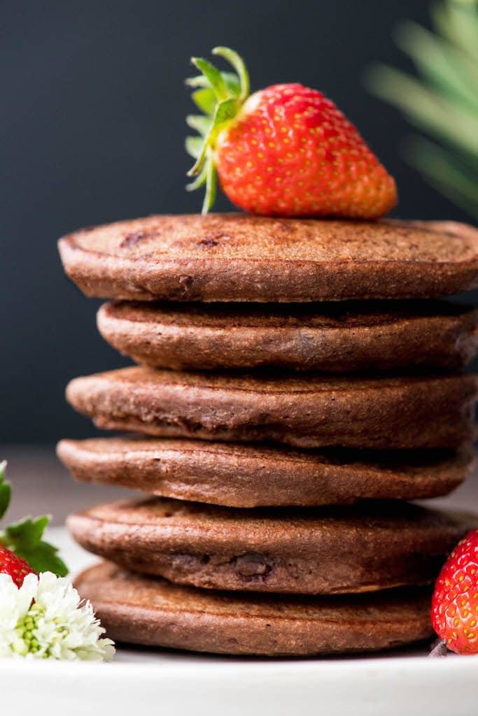 Front view of a stack of 6 Gluten-Free Healthy Chocolate Pancakes Recipe with a strawberry on top 