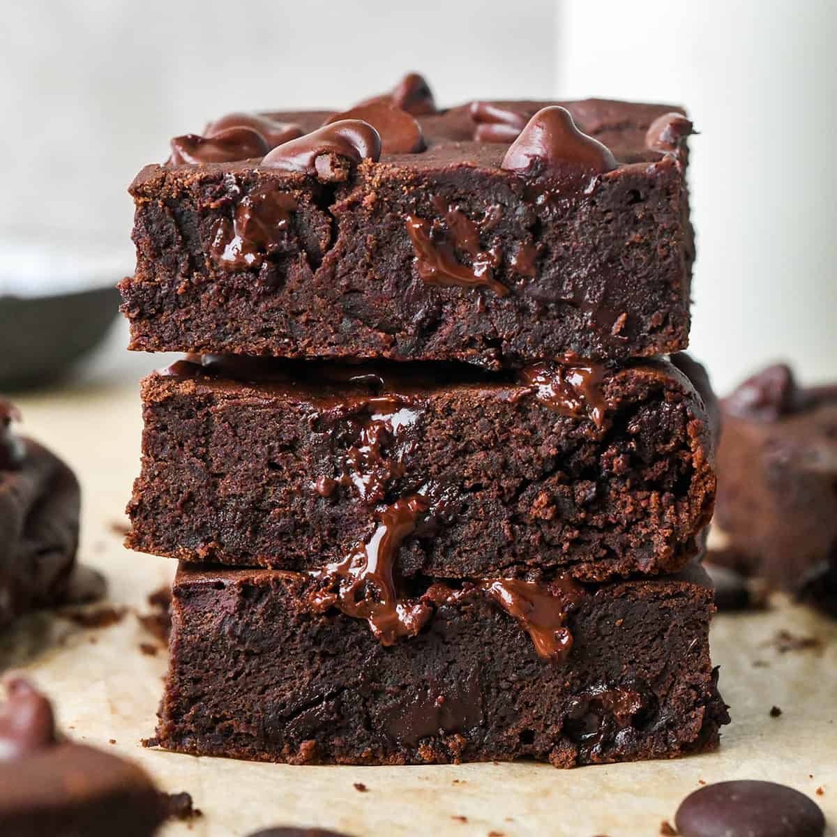 a stack of 3 black bean brownies with melty chocolate chips