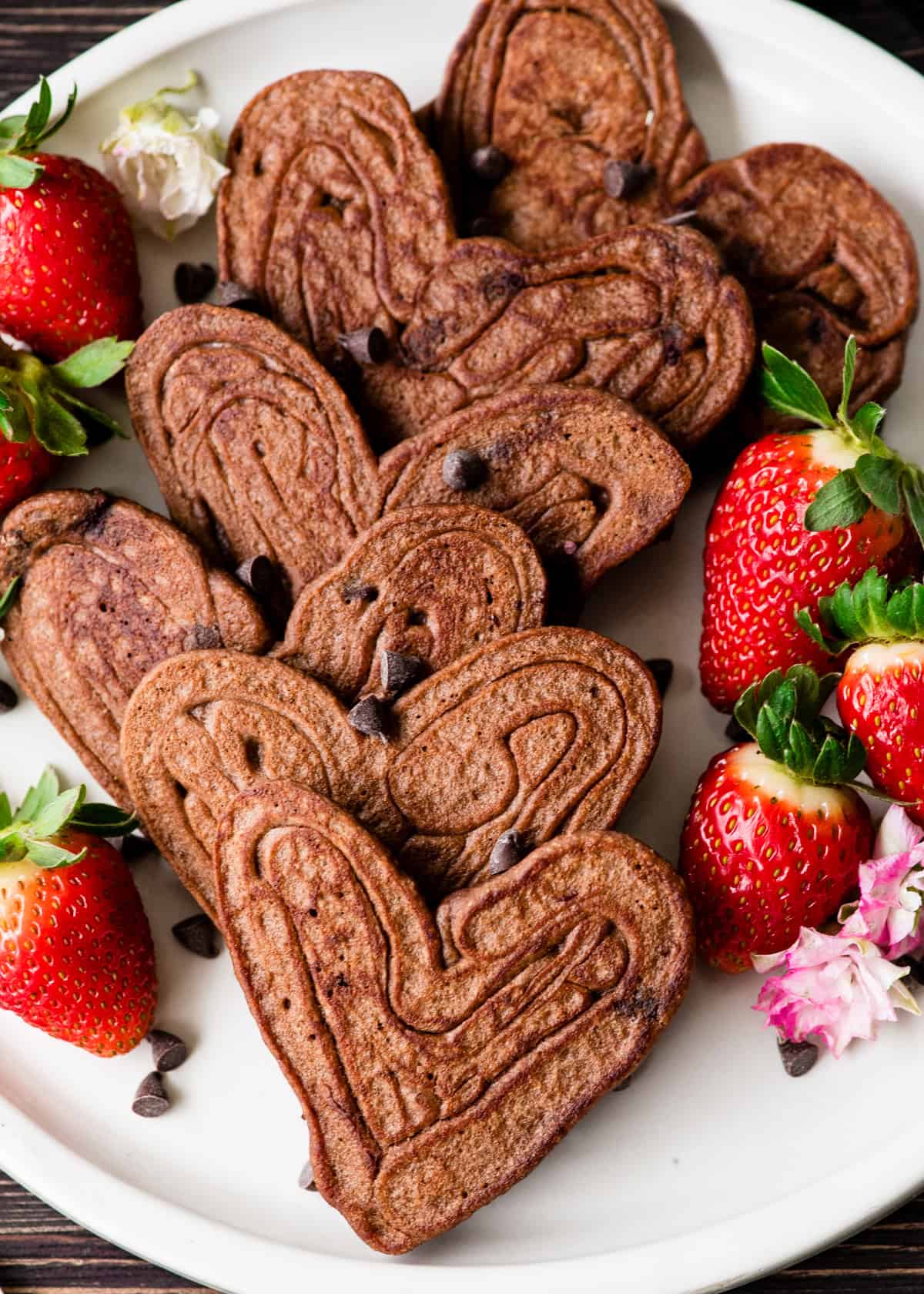 6 heart-shaped Healthy Chocolate Pancakes on a plate with berries