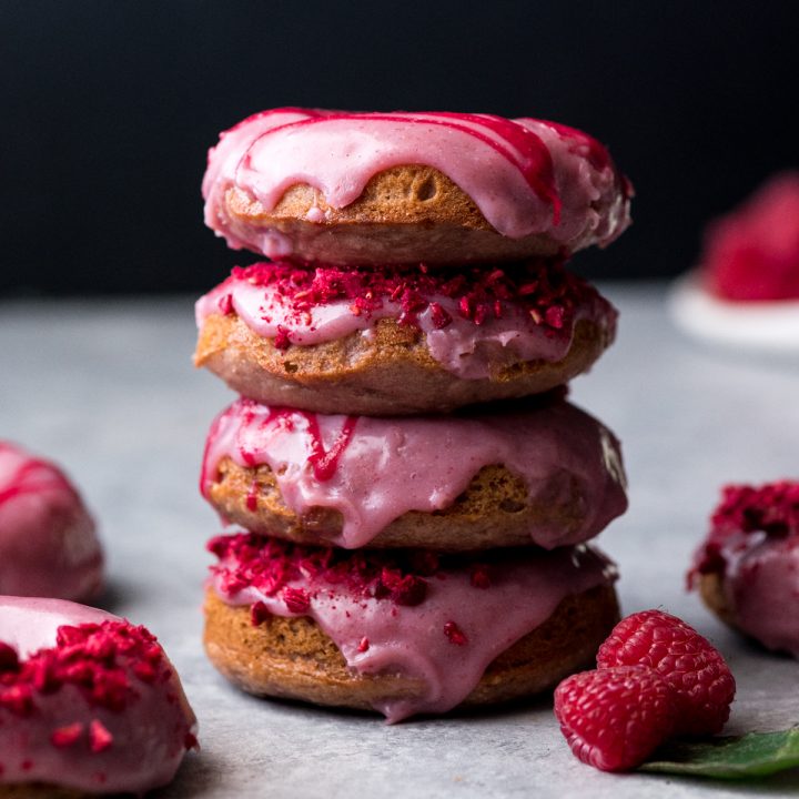Front view of a stack of four raspberry baked donuts 