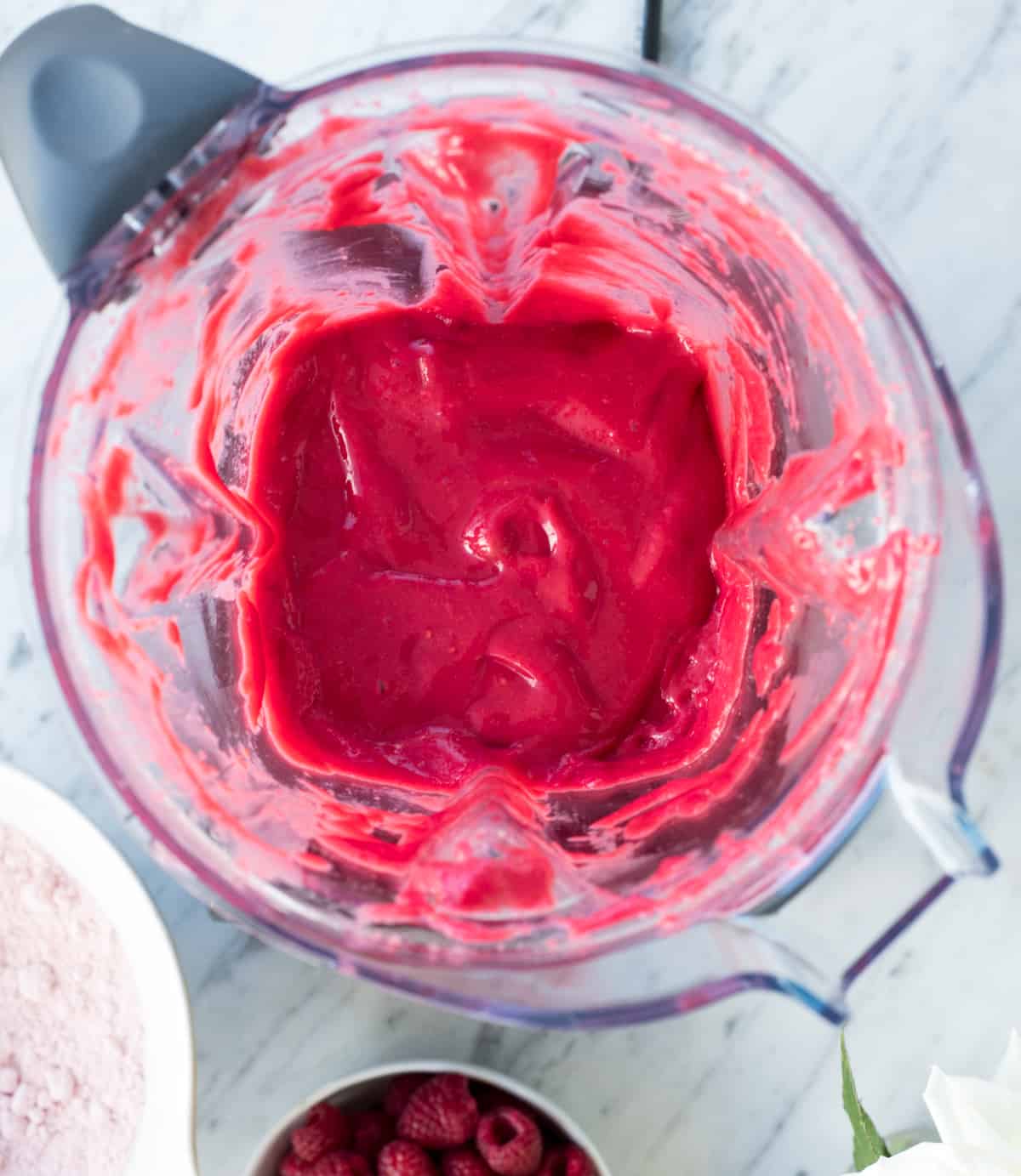 Overhead view of the raspberry puree in the vitamix blender in the making of raspberry baked donuts 
