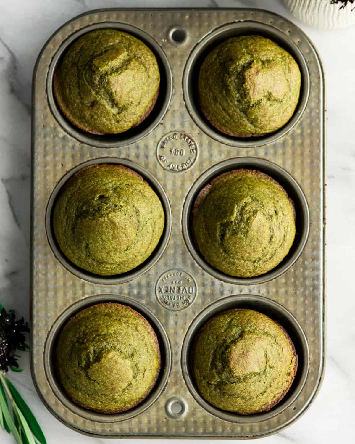 Overhead view of 8 spinach banana muffins in a muffin pan 