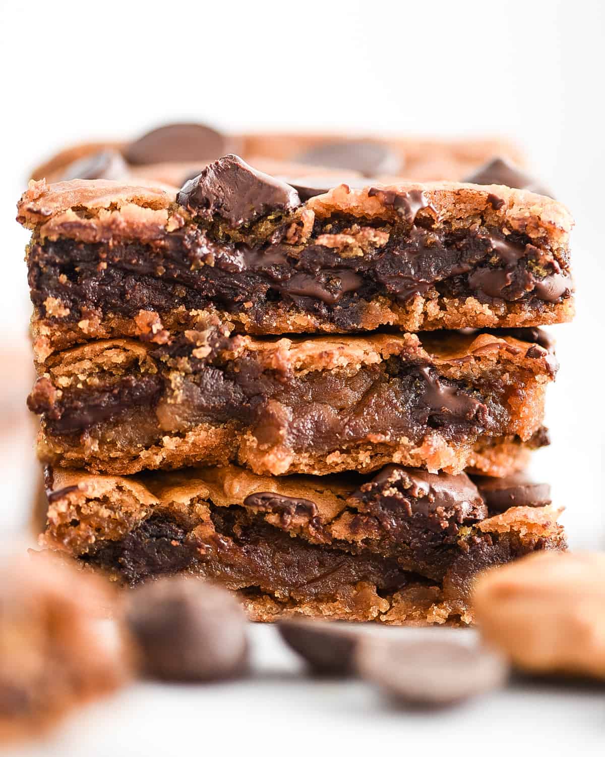 a stack of three healthy peanut butter chickpea blondies with melty chocolate fresh from the oven 