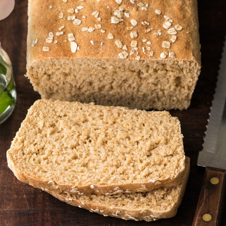 a loaf of honey wheat bread with two slices cut out of it 
