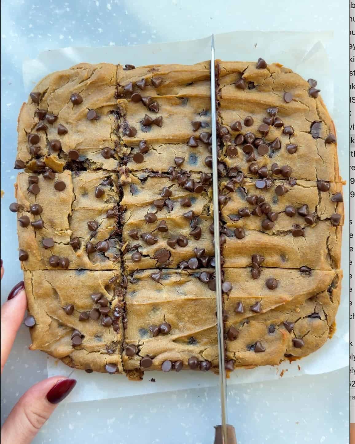 chickpea blondies being cut into 9 squares on a white cutting board