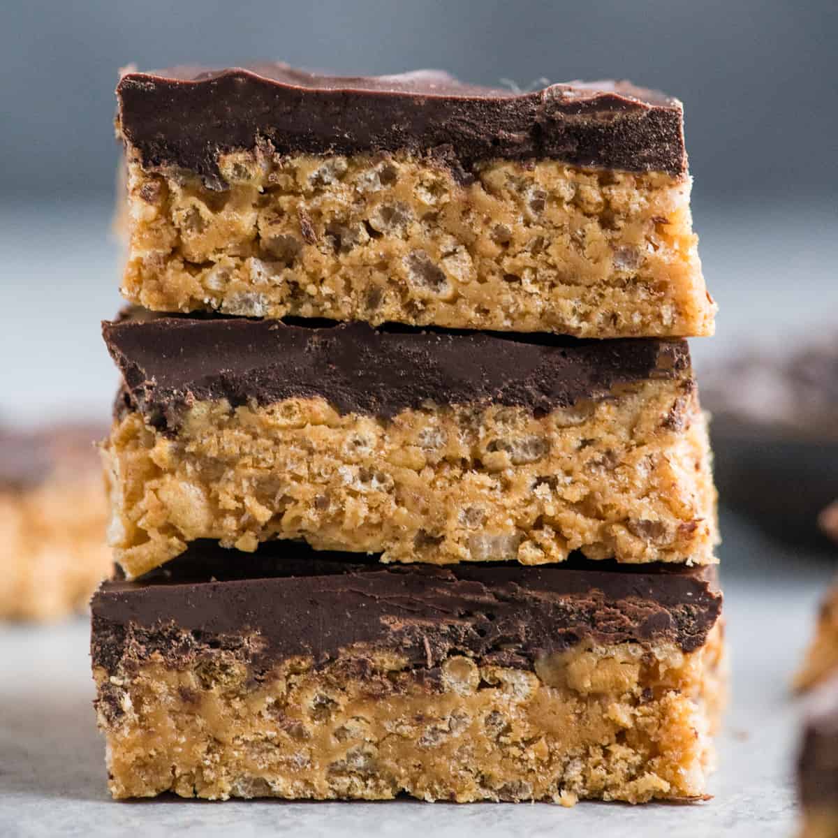 Close-up front view of a stack of three healthy peanut butter rice crispy treats. 