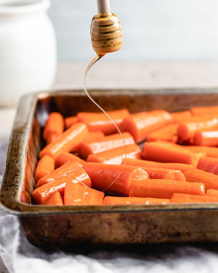 adding honey to partially roasted carrots 