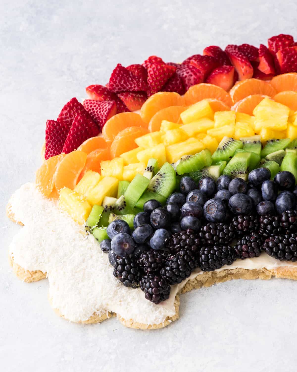 Side view of half of a full rainbow fruit pizza recipe
